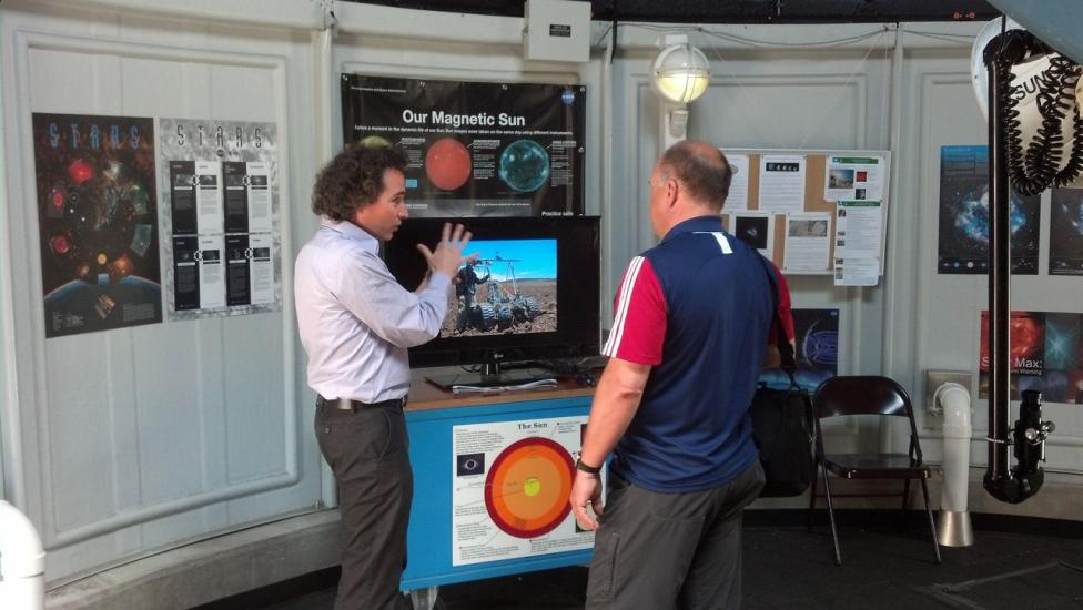 A visitor chats with a museum expert on astronomy inside the museum's observatory.