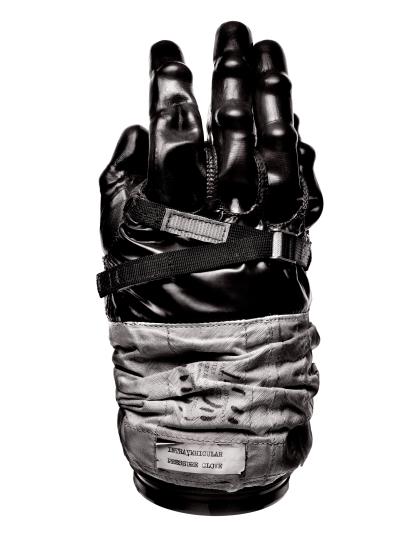 Black and white-colored, top-facing view of rubber glove intended for use on an Apollo mission.