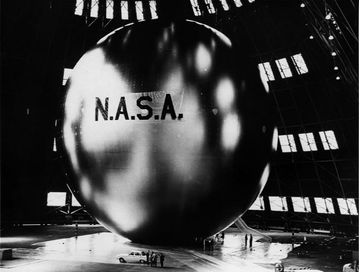 View of a large, mylar balloon with the branding of "N.A.S.A." in large, dark letters in the center of the visible balloon.