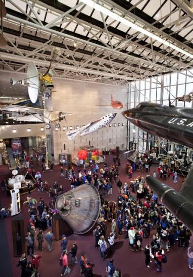 An exhibit inside the Washington, D.C. National Air and Space Museum building featuring multiple artifacts that are critical milestones in flight.