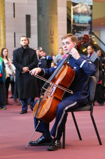 A cellist in U.S. Air Force uniform plays during a surprise performance at the Museum.