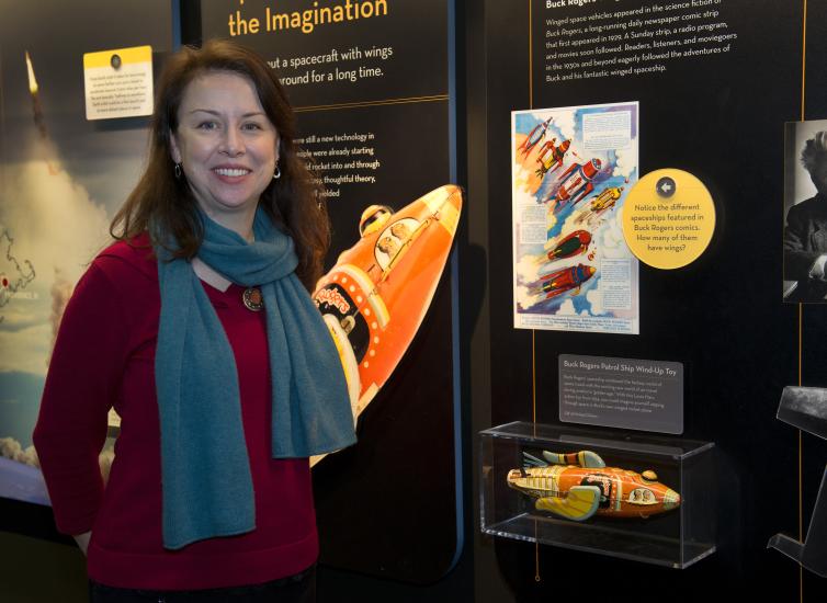 Margaret Weitekamp, the Museum's Curator of Space History, stands in front of an exhibit about space.