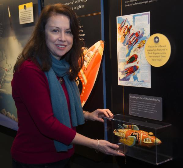 Margaret Weitekamp, the Museum's Curator of Space History, stands in front of an exhibit about space.