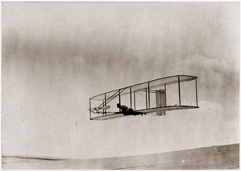 Man soars a few feet above the ground in a glider