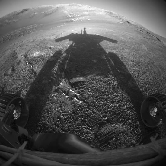 A shadow reflects from a Rover, a travelling robot, in afternoon sunlight on Mars.