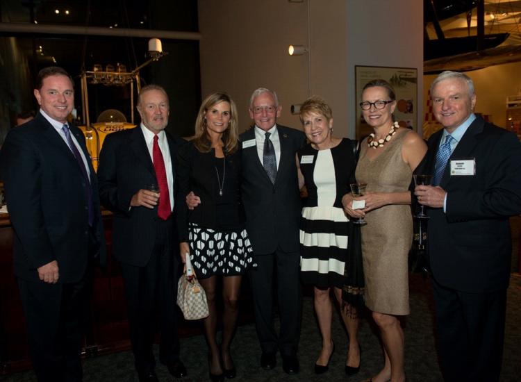 A group of people stand together at a reception held at the Museum.