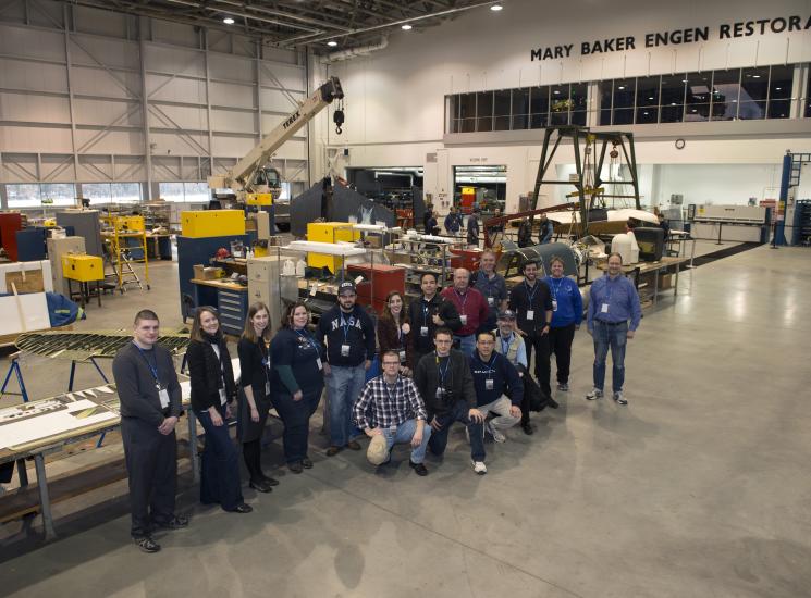 Museum staff and volunteers pose with ten social media participants inside the Restoration Hangar at the Steven F. Udvar-Hazy Center.