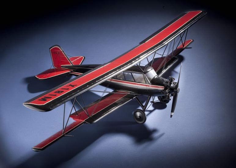 Top and side view of red and black biplane model with one engine. 