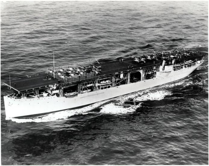 Side view of the first American aircraft carrier, a large boat that carried aircraft, in an ocean.