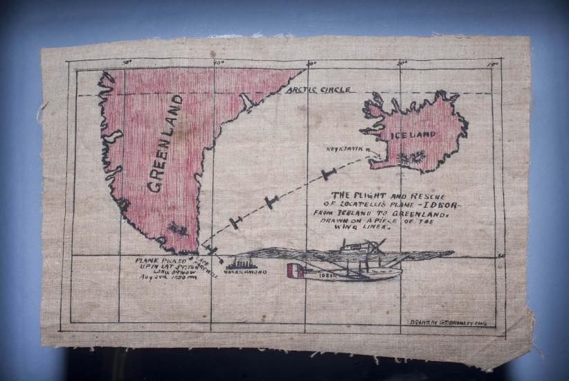 Fabric map souvenir describing a rescue following a failed world flight attempt. The map shows the rescue from near Greenland following travel from Iceland.