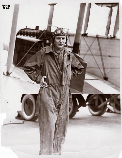 Ross Rowell, a white male pilot, poses for a portrait wearing aviator gear.