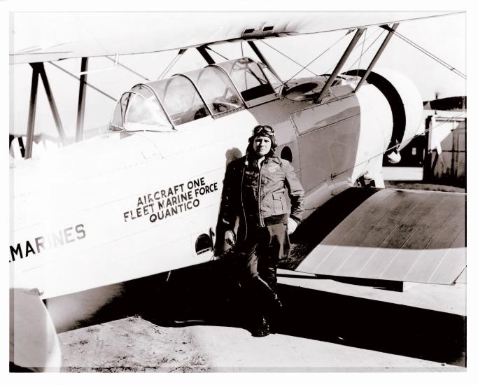 Roy Geiger, a white male pilot, stands next to an aircraft wearing aviator gear.