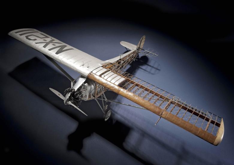 Top view of cutaway model of the Spirit of St. Louis, a silver-colored monoplane with one engine.