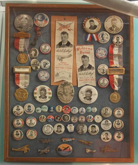 A collection of pins and ribbons celebrating Charles Lindbergh's flights.