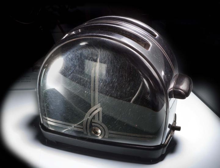 Side view of toaster with two bread slots. An etched decoration is visible on the edges and center of the toaster's side.