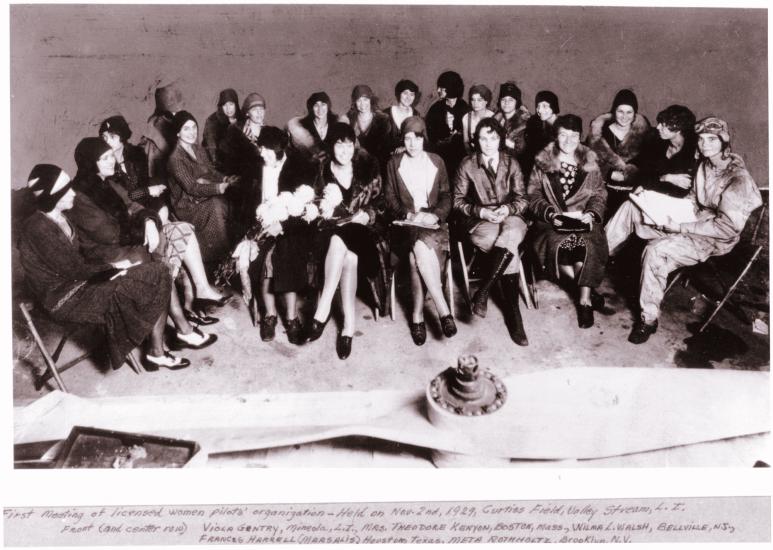 A large group of women pilots sit together.