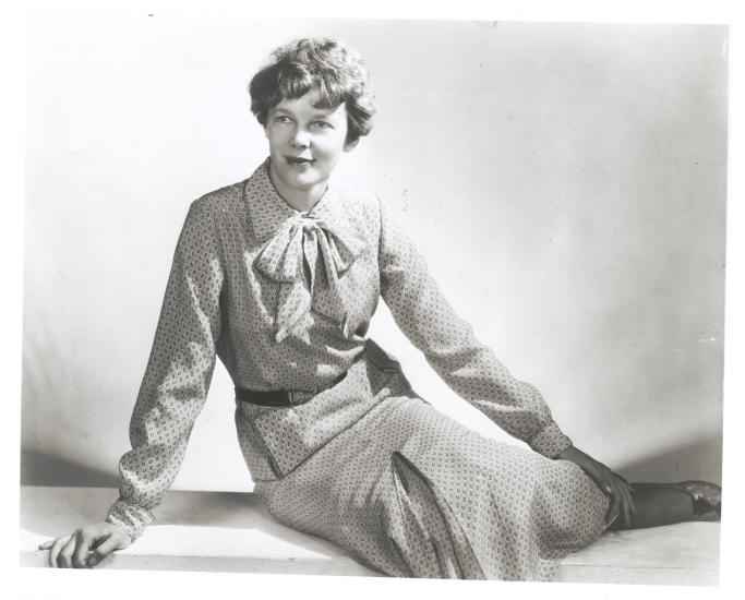 Amelia Earhart sits as she models clothing that she designed and made herself.