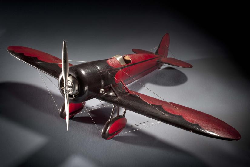 Red and brown-colored monoplane model with one engine.