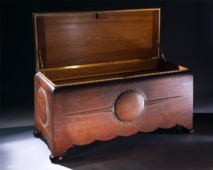 Opened wooden chest commissioned to hold the trophies, plaques, and memorabilia belonging to Amelia Earhart. The chest features motifs highlighting three of Earhart's milestone flights.