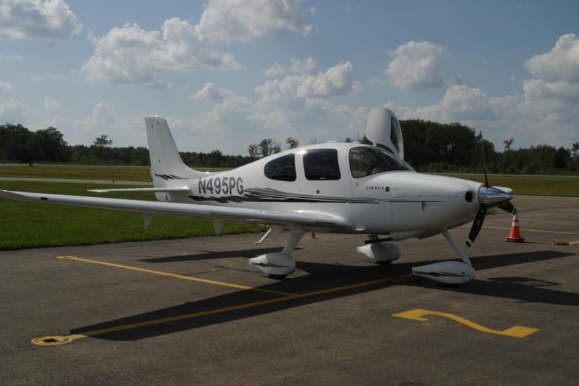 Side view of white monoplane with one engine and fixed landing gear. Registration number "N495PG" painted near the rear of the fuselage in black paint.