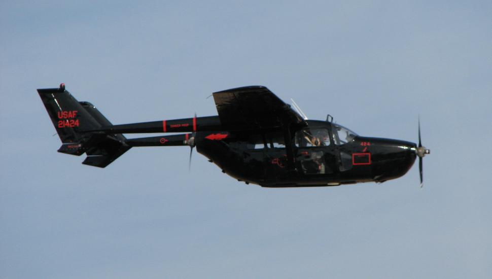 Side view of black, twin engine monoplane with engines placed on the back of the wings. Monoplane is in flight.