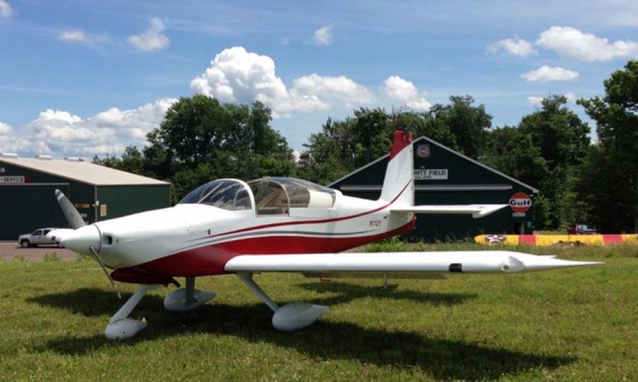 Front view of white and red-colored monoplane with single engine and fixed landing gear.