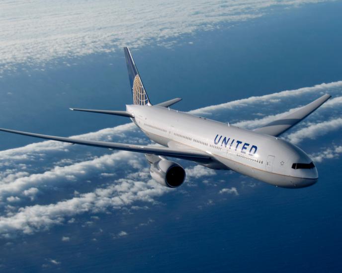 A Boeing 777 commercial jet with white, blue, and yellow United Airlines livery.