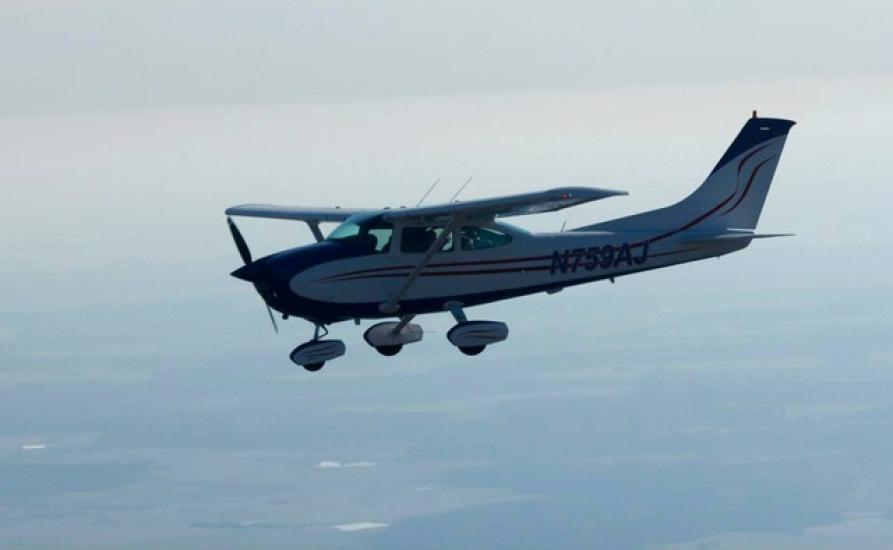 Side view of white monoplane in flight. Monoplane has single engine and fixed landing gear.