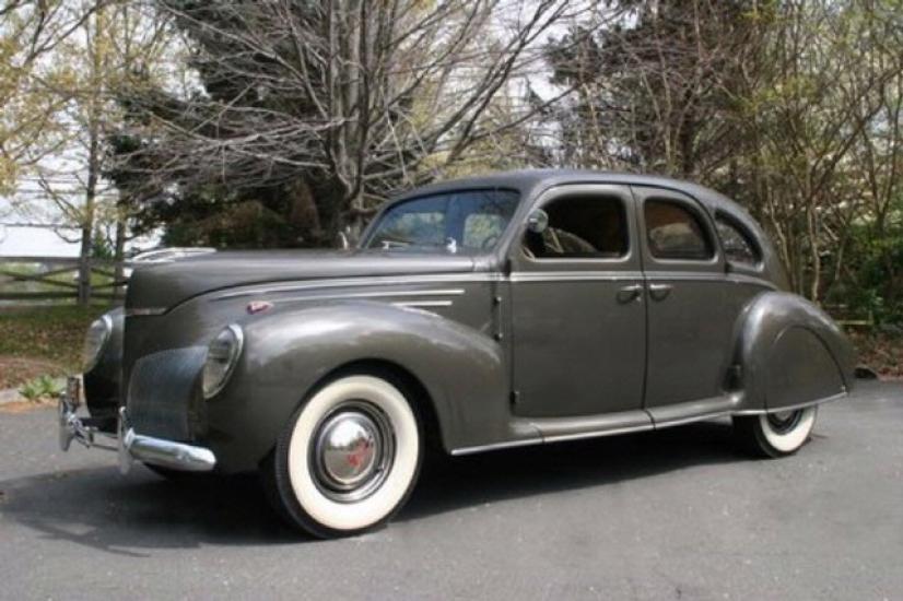 Side view of a 1930s, gray, four-door automobile.