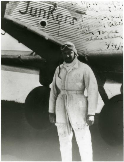 John C. Robinson, an African-American male pilot, poses informally in front of an aircraft.