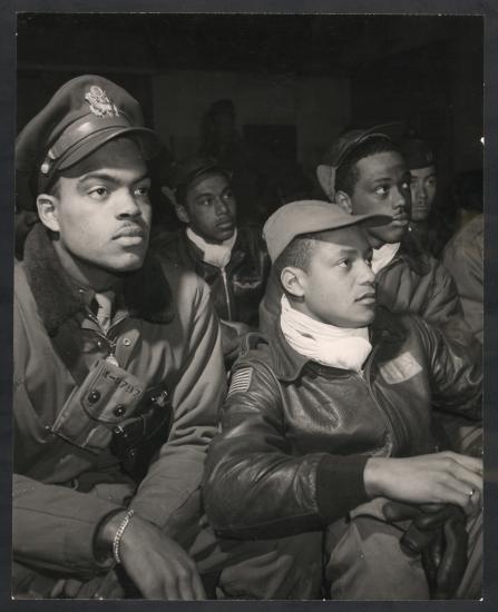 African-American male pilots listen to a mission briefing together.