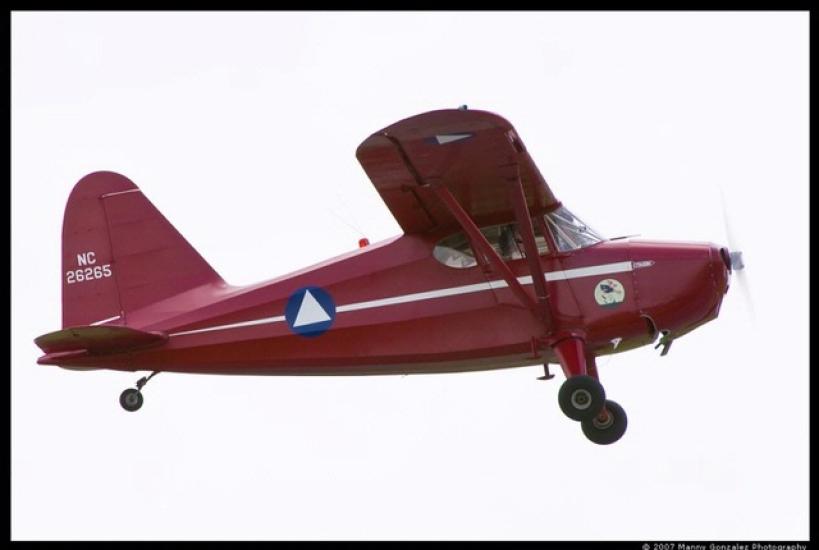 Side view of red monoplane with one engine. Registration number "N26265" is painted in white on the rudder.