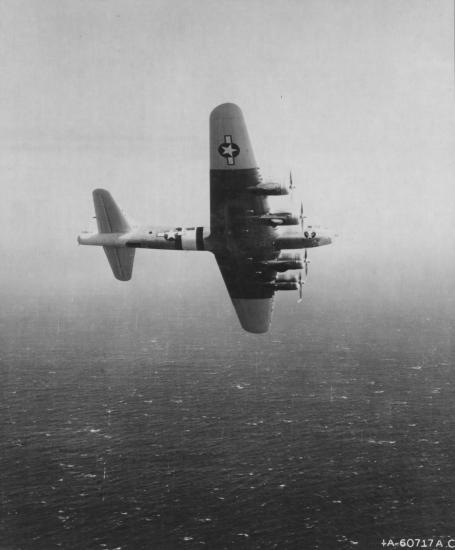 View of a U.S. military monoplane during a test flight over an ocean.