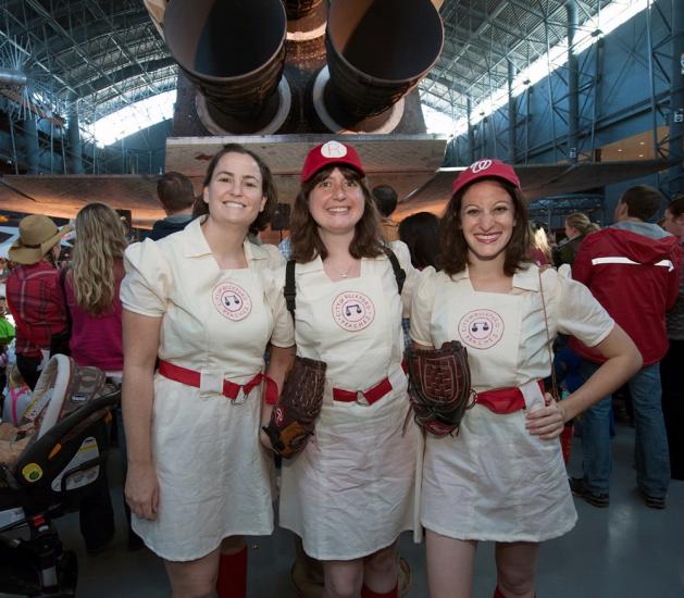 Three women wearing baseball costumes inspired by the movie "League of Their Own" pose together at the Museum's annual Halloween event.