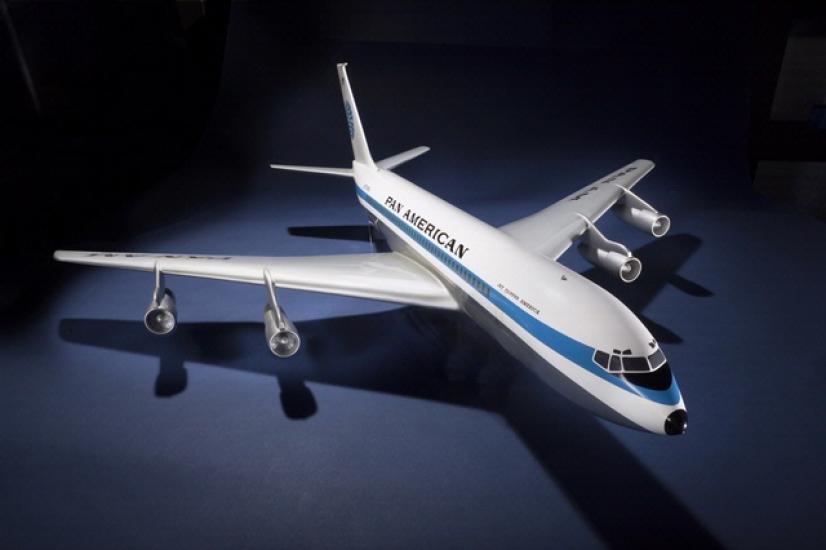 Plastic, white and blue commercial aircraft model with four engines attached to the sides of the plane. Aircraft has white and light blue Pan American World Airways livery.