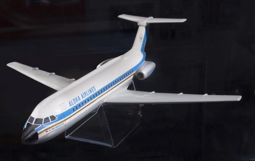 White, plastic commercial aircraft display model with a blue stripe. Aloha Airlines is written near the front of the fuselage on the side of the plane.