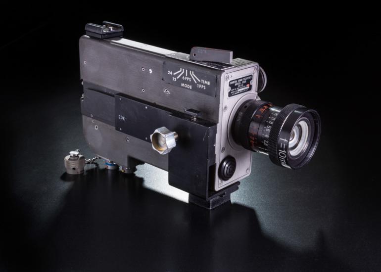 Film camera with rectangular prism base and single lens.