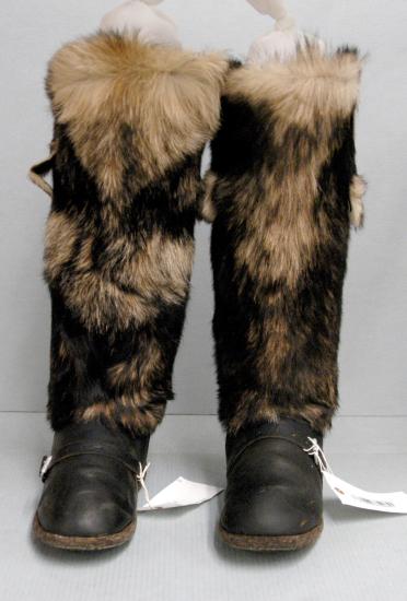 Pair of survival boots with black leather base and black and tan-brown fur on the sleeves.