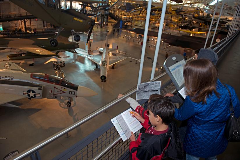 Three younger Museum guests observe objects in the Museum while playing a Museum-sanctioned alternate reality game.