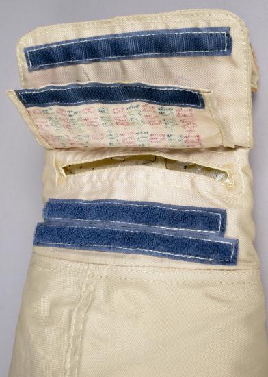 Close-up view of glove on cosmonaut suit, featuring a flap that would include a written checklist for spacewalks.