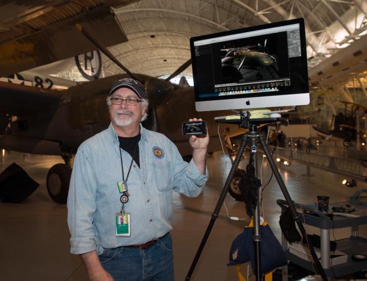 A Museum staff member uses a display monitor to provide photography advice at an open house event for the Museum.