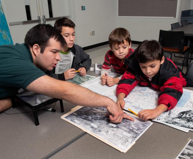 A family of four people look at maps as part of a game at the Udvar-Hazy Center.