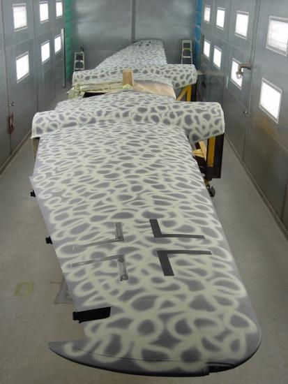 Side view of wings of an aircraft after it received white-colored paint to match its original pattern during a restoration.