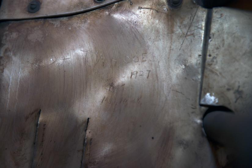 Signatures from engineers and guards etched onto a portion of a silver monoplane. 