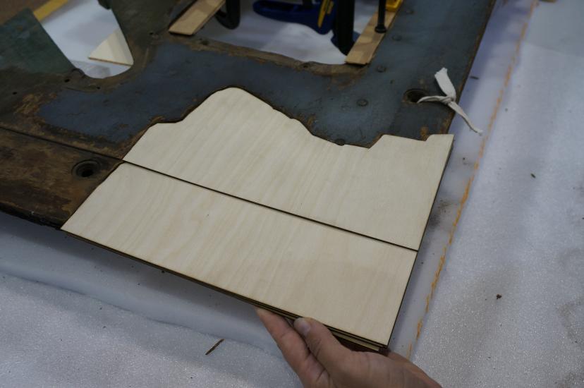 A Museum staff member places a fifth layer of plywood intended for use in repairing holes in a World War II era aircraft.