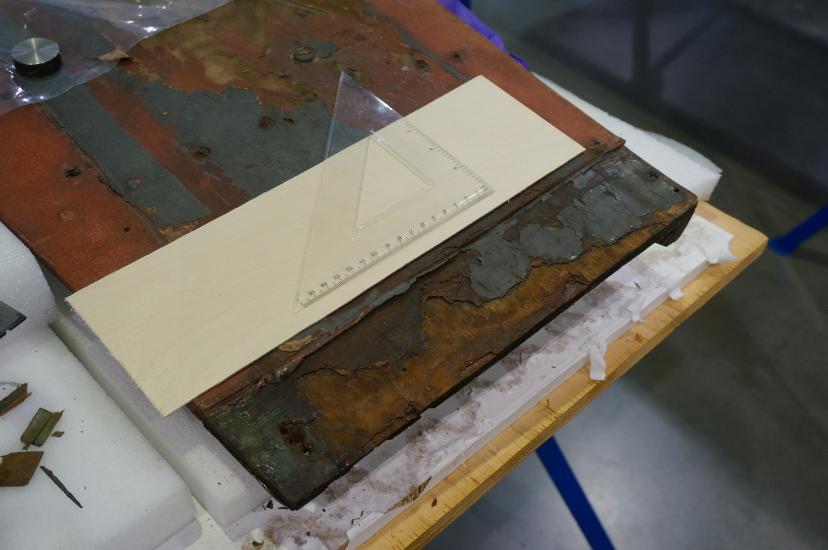 A deteriorated section of a World War II era aircraft prior to receiving conservation treatments. Discoloration and loss of materials can be seen.