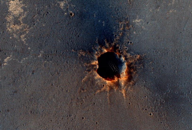 A photo of the "Santa Maria" Crater on Mars, a large crater with reddish-orange edges.