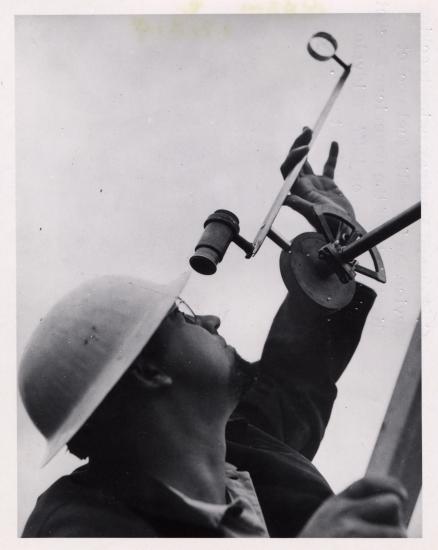 Gawain Edward “Ed” Pendray, a man, uses a tracking device to view rocket flight tests.