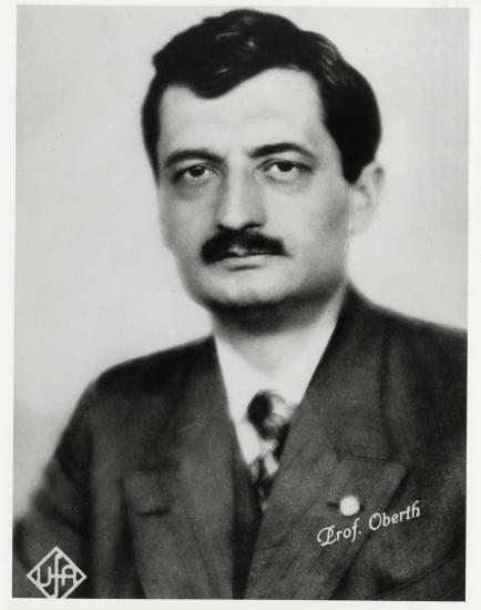 A portrait of a man with a black mustache wearing a suit.