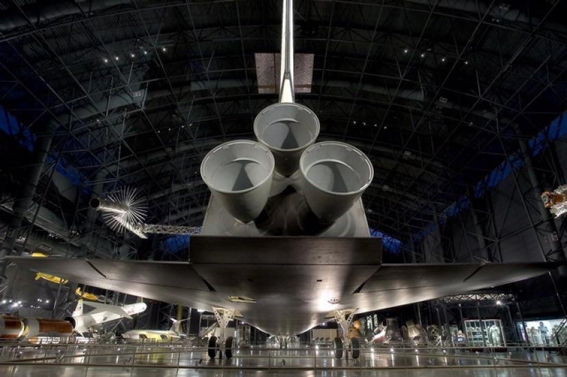 View from behind the Space Shuttle Enterprise showing three engines, tail, and lower side of wings of the orbiter.